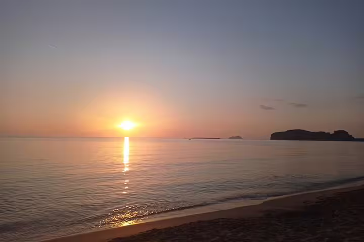 Breathtaking sunset view at Falasarna Beach with golden hues reflecting on calm waters for a serene private tour experience.
