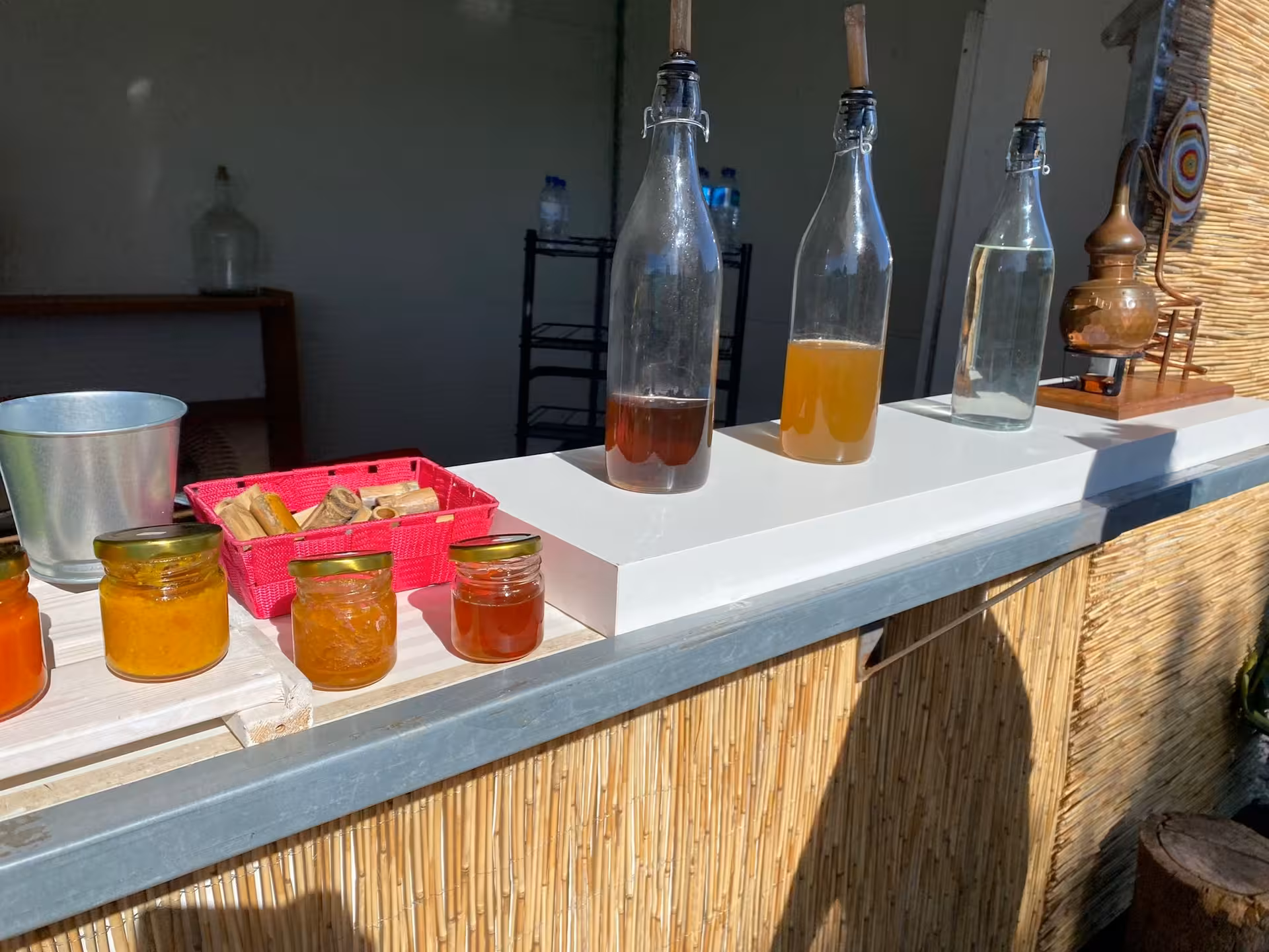 Sunlit counter with homemade jams, spirits and copper still on the Sunset with sparkling wine local tasting tour