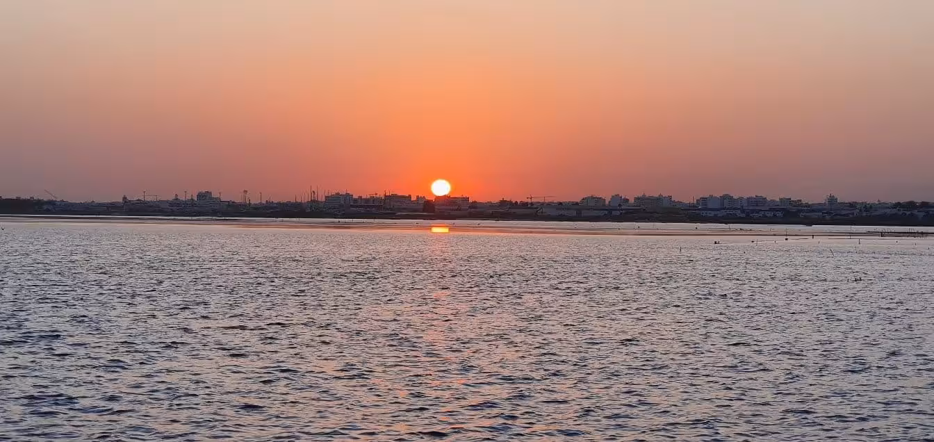 Stunning sunset view over calm waters in a coastal city, perfect for a romantic Sunset Tour Privado experience.