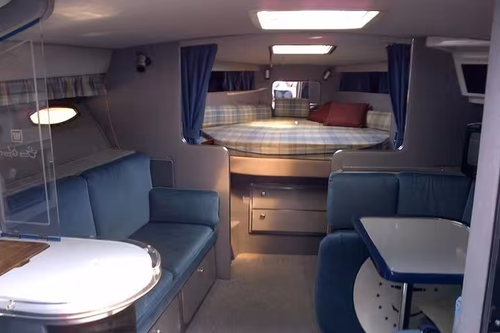 Comfortable yacht cabin interior with lounge seating and double berth, perfect for a private sunset yacht cruise