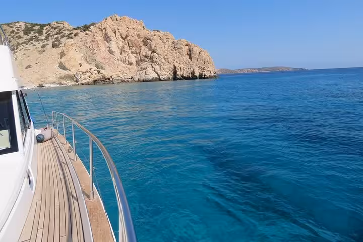 Yacht deck beside turquoise bay and rocky coastline, scenic stop on a private sunset yacht cruise adventure