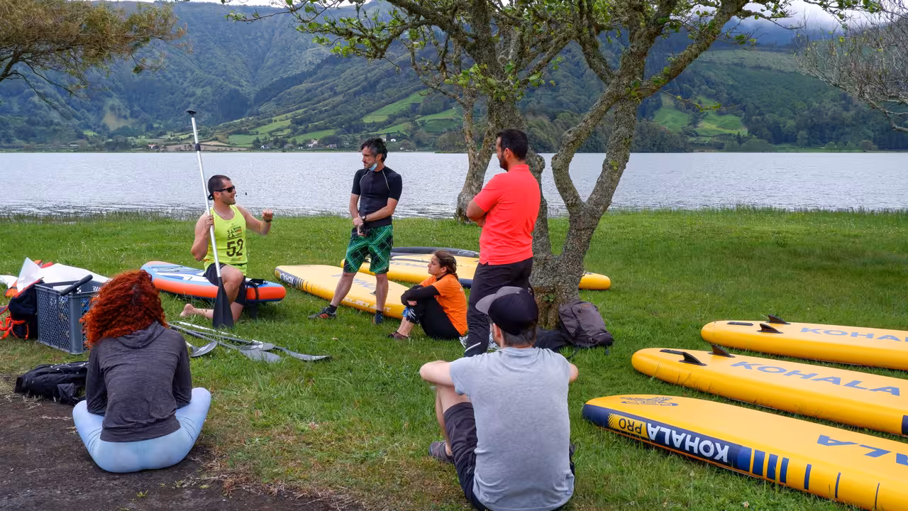 Group SUP lesson at Sete Cidades lagoon with instructor, yellow paddle boards and scenic volcanic landscape in the Azores