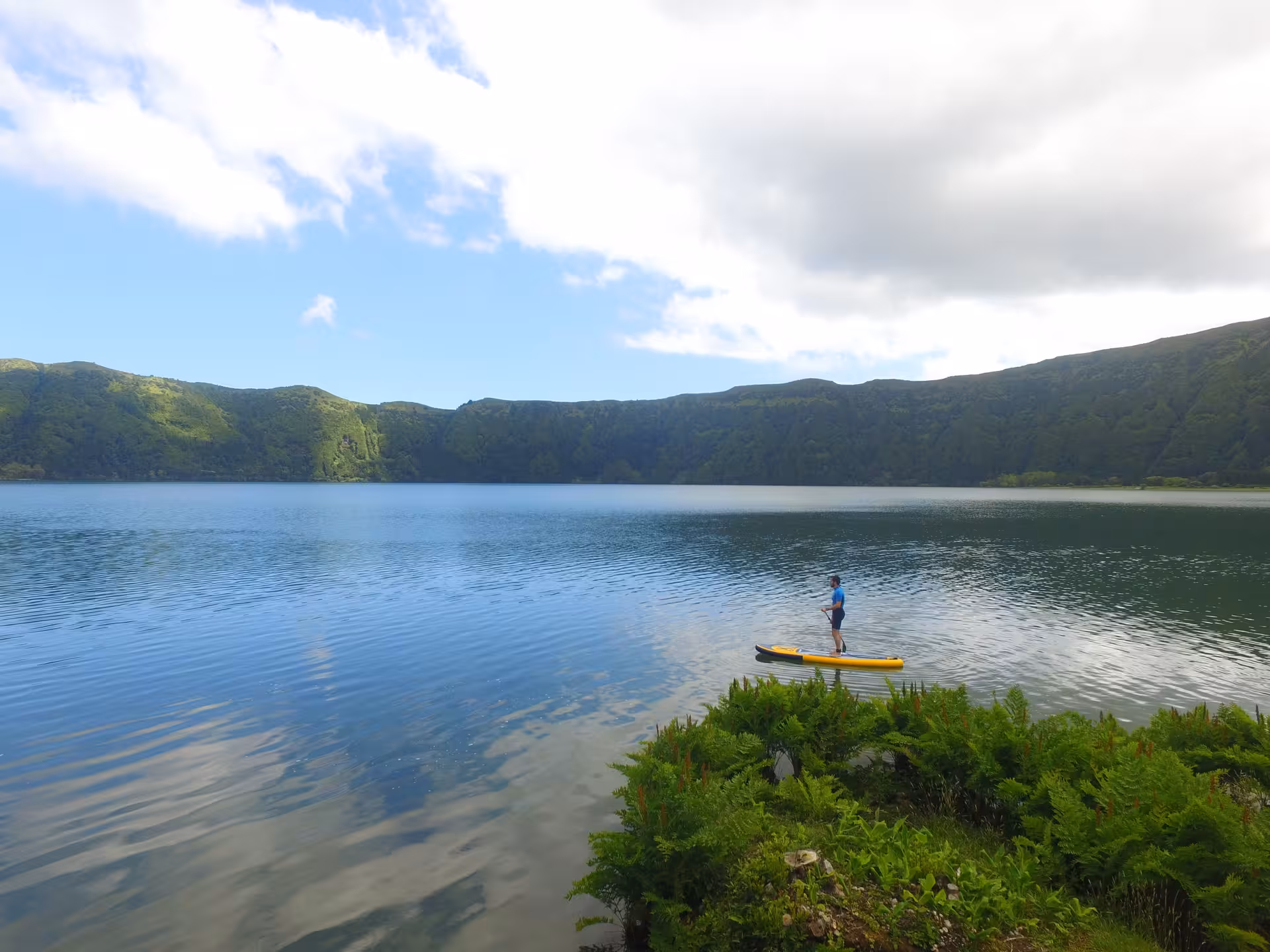 Solo paddler enjoying a peaceful SUP Rental Seven Cities session on the blue crater lake of Sete Cidades, São Miguel