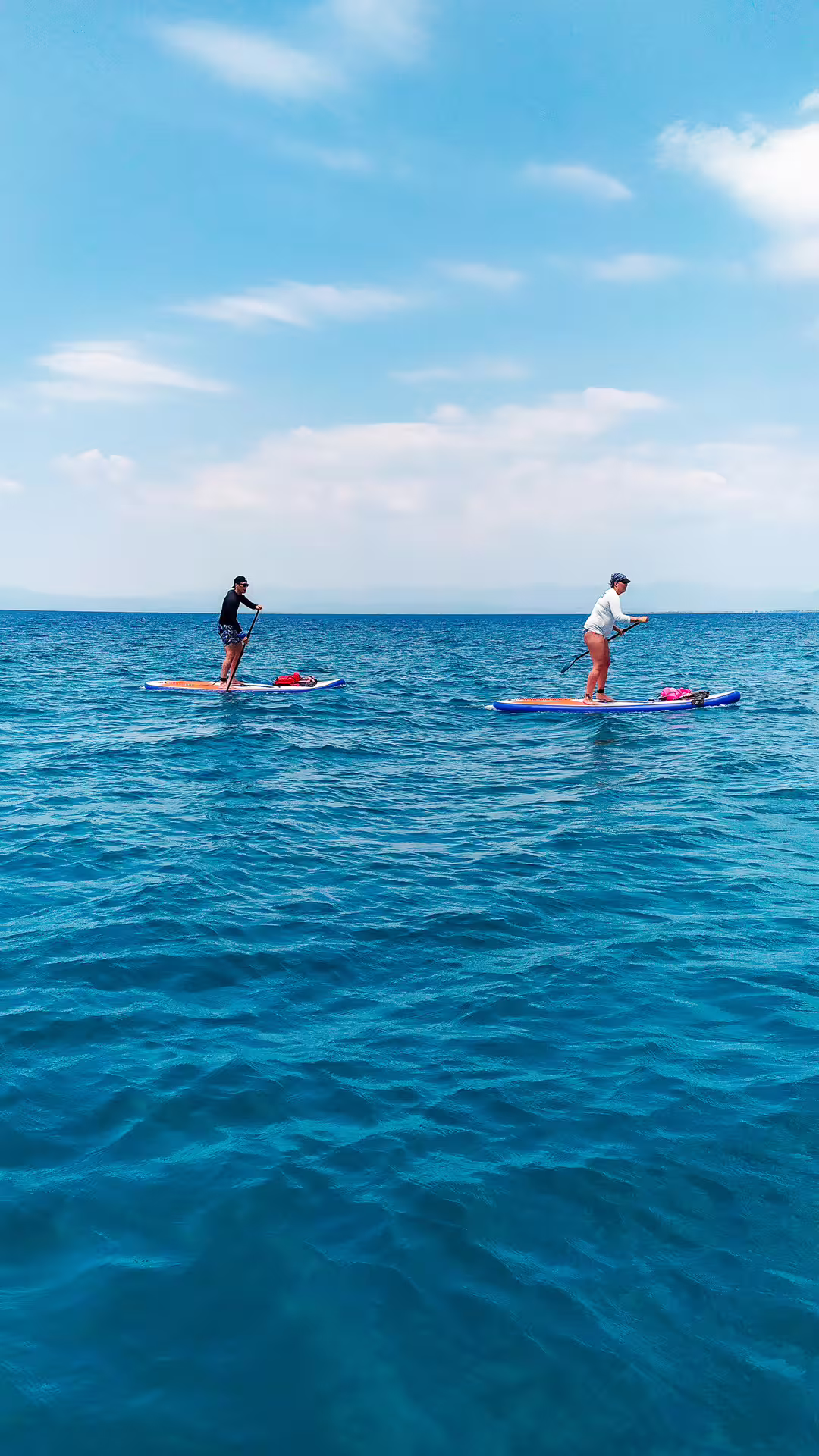 Two paddlers on stand up paddleboards in open sea during a guided SUP tour in Kalamata, Greece