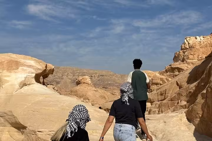 Group hiking through Sinai desert rocks on Super Colored Canyon jeep tour from Sharm El Sheikh with Blue Hole stop