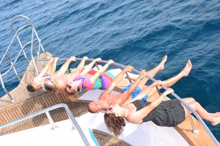 Guests sunbathe on a yacht deck during Super Giftun Island boat trip, Red Sea snorkeling and cruise day
