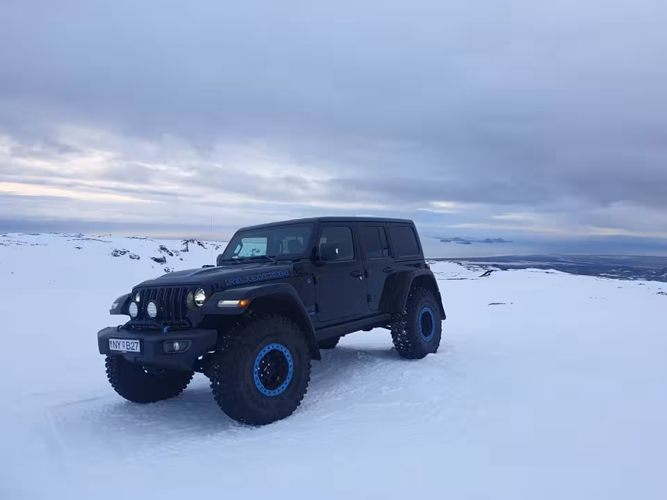 Black lifted Jeep Wrangler with blue rims on Eyjafjallajokull glacier snowfield in Iceland