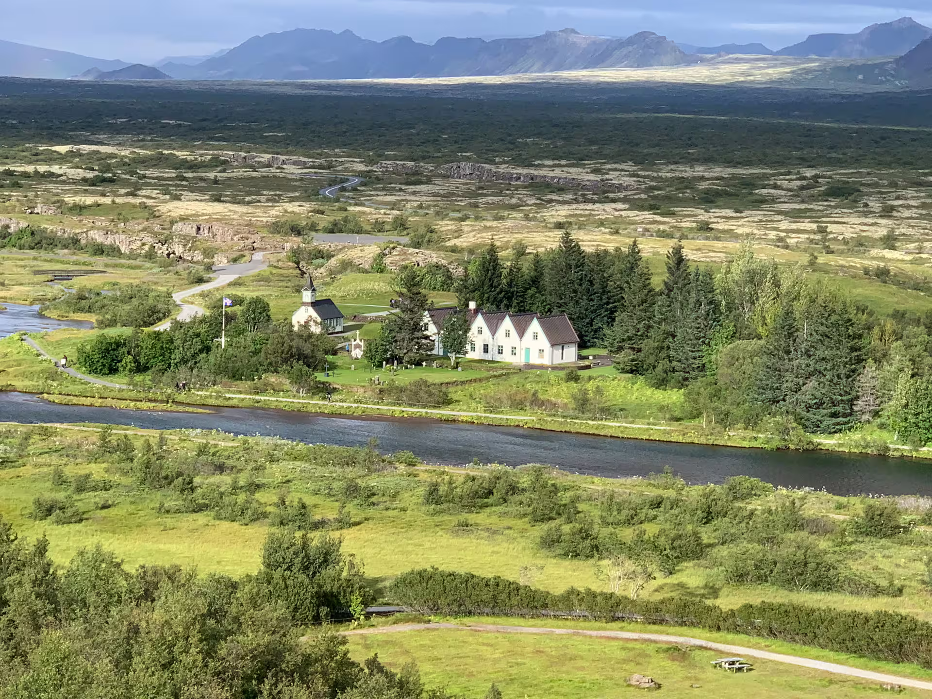 Aerial view of Thingvellir National Park with church, white buildings, river, and volcanic landscape in Iceland