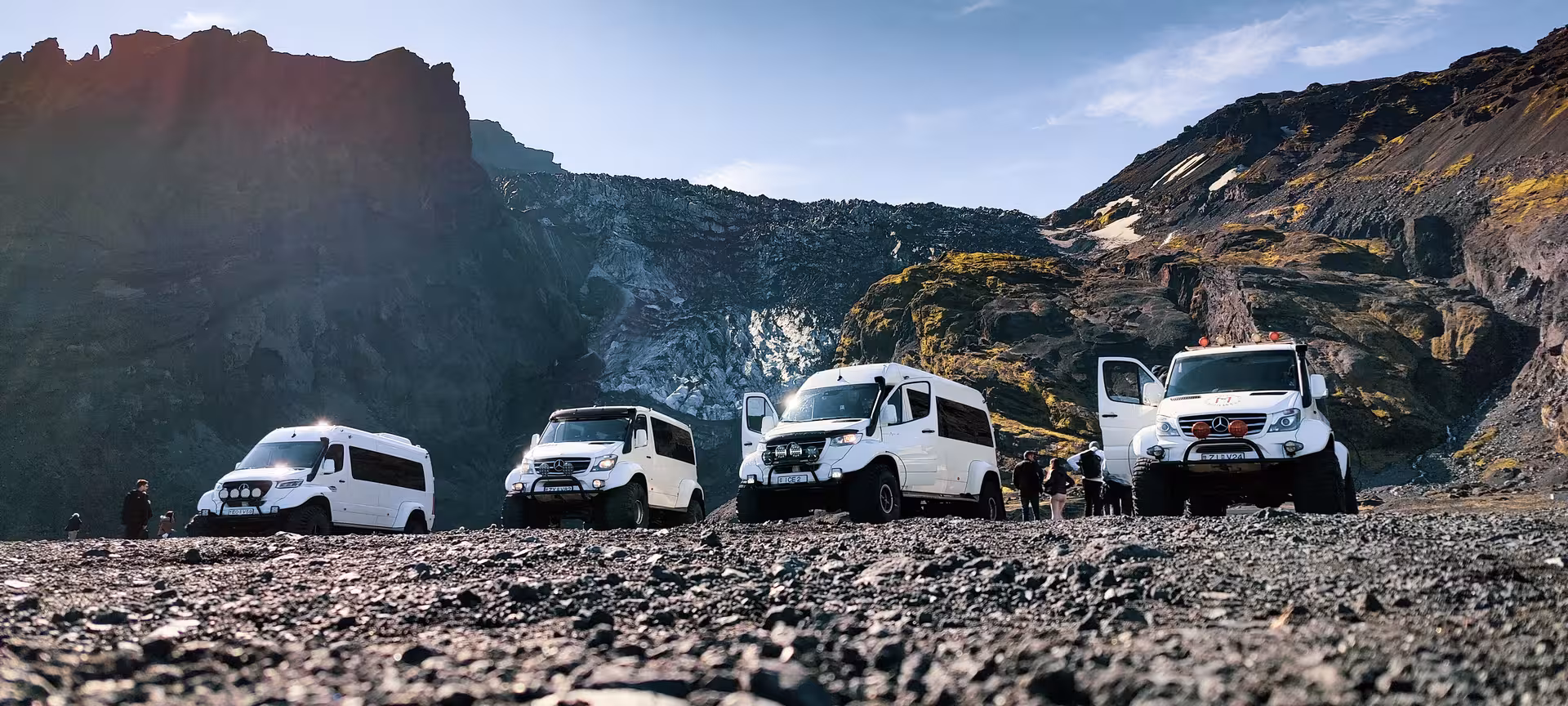 Fleet of white superjeep 4x4 vans parked in Thorsmork volcanic valley Iceland with dramatic rocky mountains