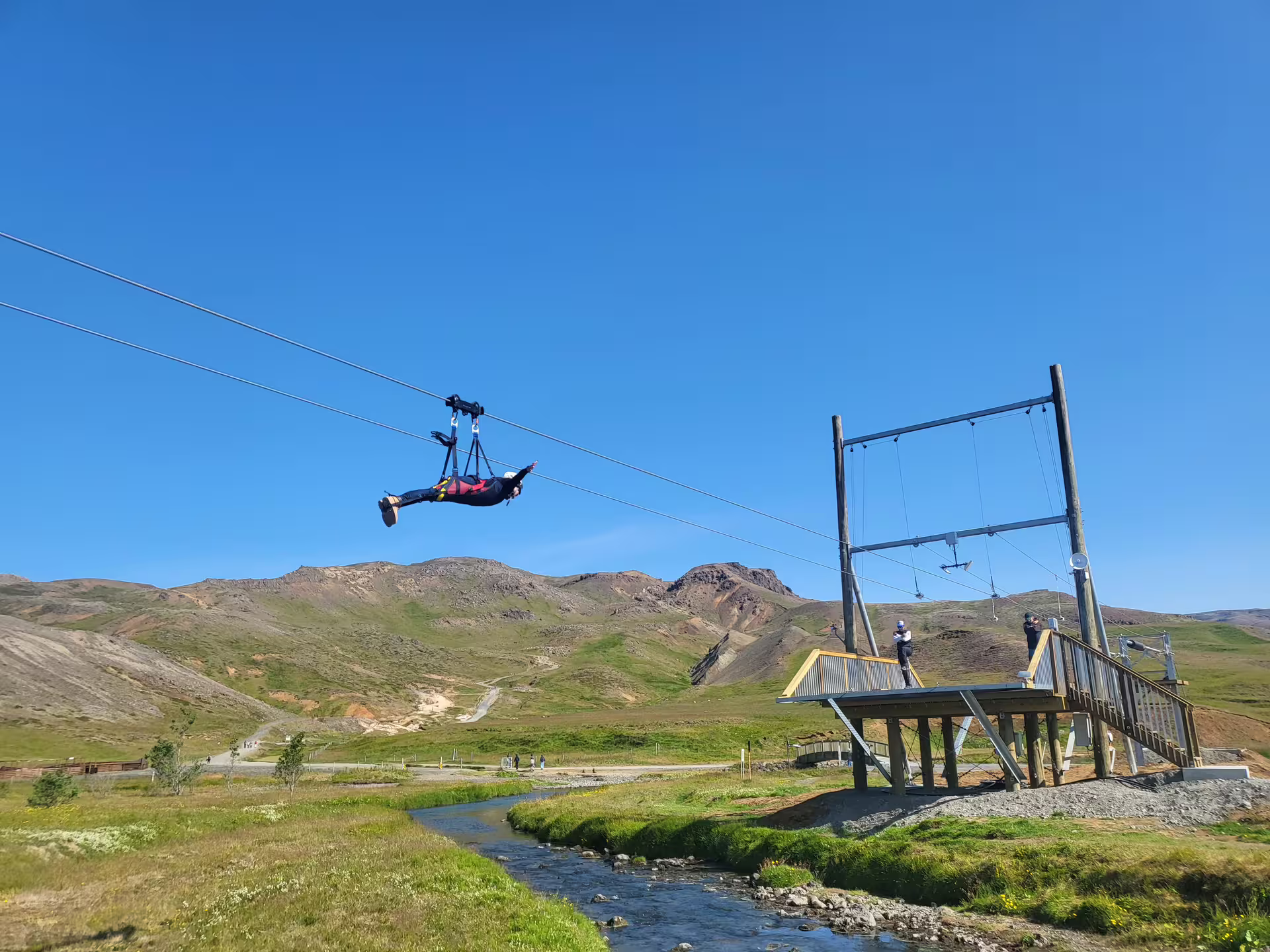 Person enjoying a thrilling Superman-style zipline ride over scenic mountain landscape, showcasing adventure and excitement.