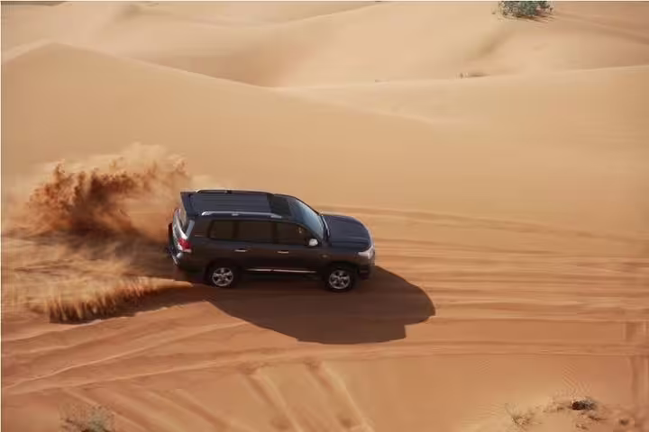 SUV performing a thrilling dune bash across golden desert sands, capturing the excitement of an adventure safari.