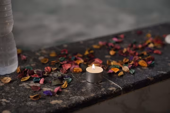 Aromatherapy candle and dried petals creating a calm spa mood for a Swedish massage in Sharm El Sheikh