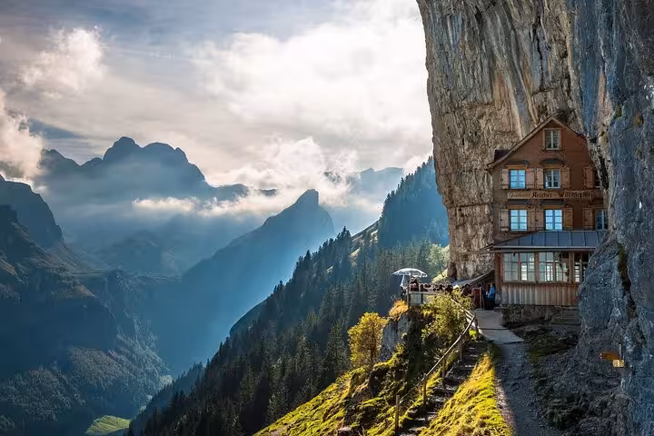 Breathtaking view of the cliffside Aescher Hotel overlooking the Swiss Alps, perfect for a private guide experience.