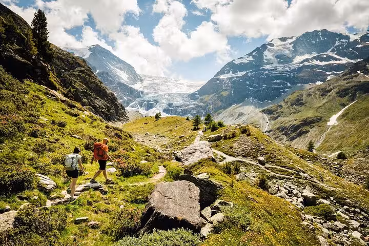 Hikers exploring a scenic trail in the Swiss Alps with stunning mountain views, perfect for a three-day guided tour.
