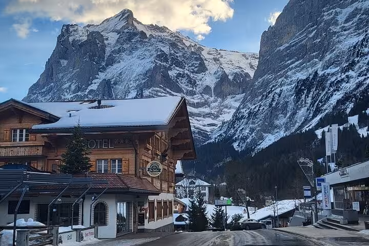 Charming alpine hotel set against majestic snow-capped mountains in a picturesque Swiss village.