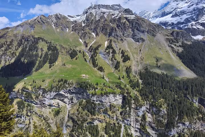 Panoramic green alpine slopes and rugged peaks on the 4-day Swiss Magic through the Alps trekking tour in Switzerland