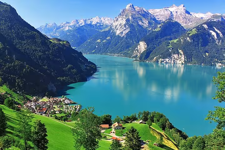 Stunning view of a turquoise lake surrounded by majestic Swiss Alps, highlighting the beauty of Swiss Travel Pass Tours.