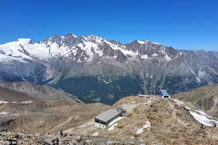 Panoramic view of snowcapped Swiss Alps and mountain station, Jungfrau Region scenery on 4-day tour from Zermatt