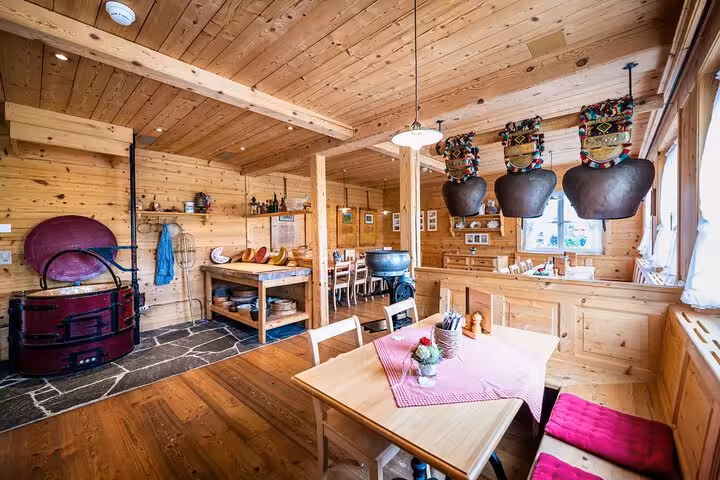 Cozy Swiss chalet interior with wooden decor, traditional bells, and rustic dining area.