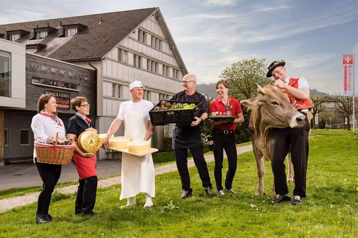 Local artisans and a cow outside a traditional Swiss cheese shop in St. Gallen, showcasing authentic culture and cheese.