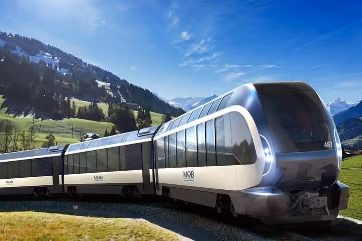 Modern panoramic Swiss train gliding through lush green valleys with snow-capped mountains in the background.