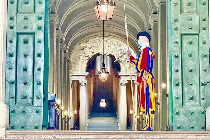 Colorful Swiss Guard standing at ornate Vatican entrance on St Peter’s Basilica VIP early access dome climb private tour