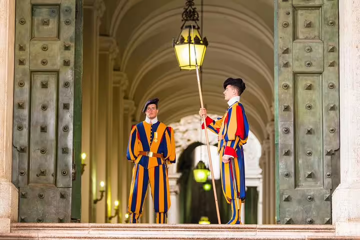 Colorful Swiss Guards standing at Vatican City entrance during Rome private Vatican Museums and Sistine Chapel guided tour