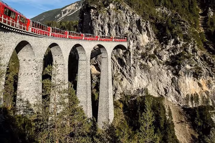 Historic Swiss train crossing the Landwasser Viaduct, offering breathtaking views of the Swiss Alps.
