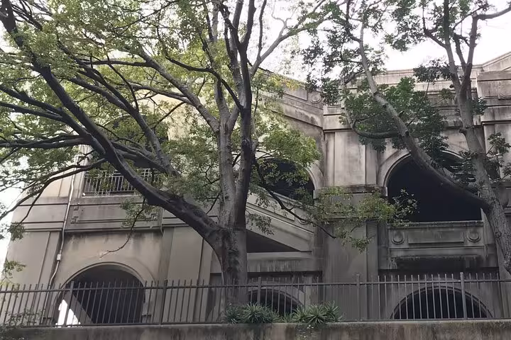 Historic stone arched building with iron fence and trees on Sydney ghost walking tour route
