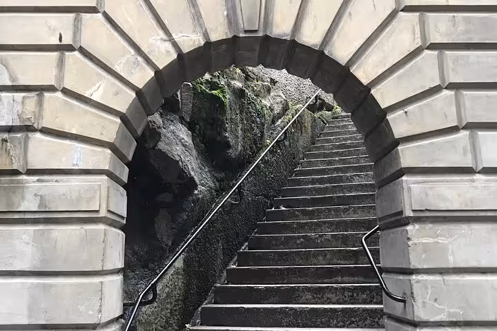 Stone archway entrance with dark moss-covered steps leading upward on Sydney ghost walking tour