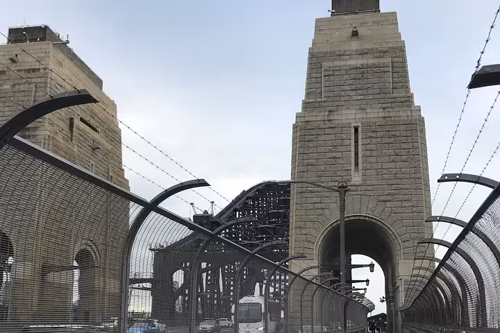 Sydney Harbour Bridge pylons and pedestrian walkway with anti-climb fencing on overcast day