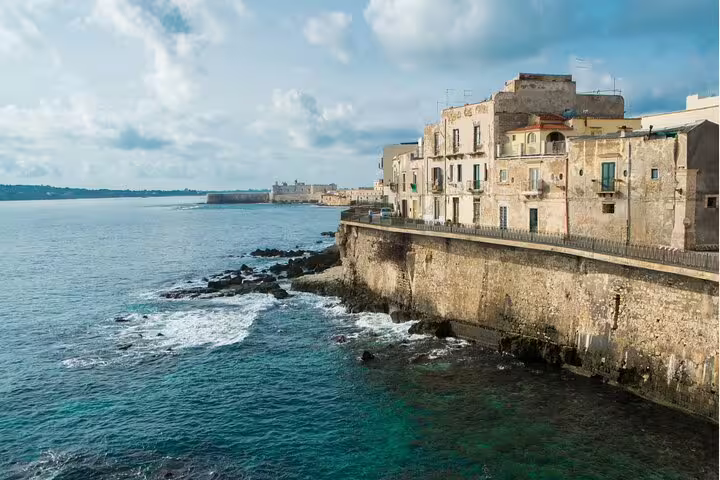 Ortigia seafront in Syracuse with historic waterfront buildings and waves on a self-guided scavenger hunt tour