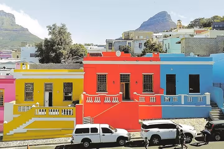 Vibrant Bo-Kaap houses with Table Mountain in the background, showcasing colorful Cape Town architecture.