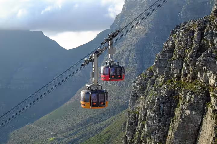 Cable cars ascending Table Mountain, offering stunning views of Cape Town on a private tour adventure.