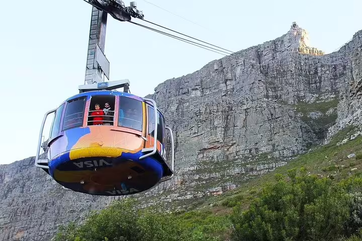 Colorful cable car ascends Table Mountain, offering breathtaking views of the iconic South African landmark.