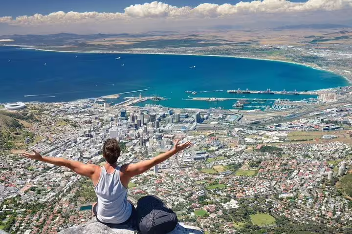 Traveler enjoying panoramic views of Cape Town and Table Bay from the heights of Table Mountain.