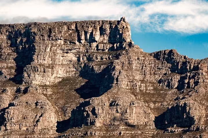 Majestic view of Table Mountain's rocky cliffs under a clear sky, a highlight of the Cape Town tour to Cape Point and Boulders Beach.