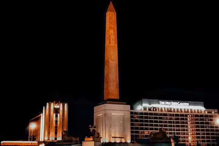 Illuminated Tahrir Square obelisk at night in downtown Cairo, a highlight on the half-day tour with dinner