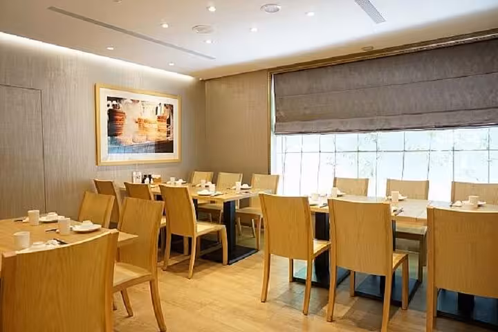 Elegant dining area at Taipei Hungzhou Xiaolongbao with wooden tables, modern decor, and soft lighting for a cozy ambiance.
