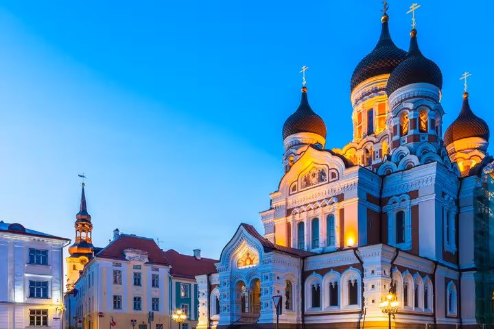 Alexander Nevsky Cathedral with golden onion domes illuminated at dusk in Tallinn's Old Town