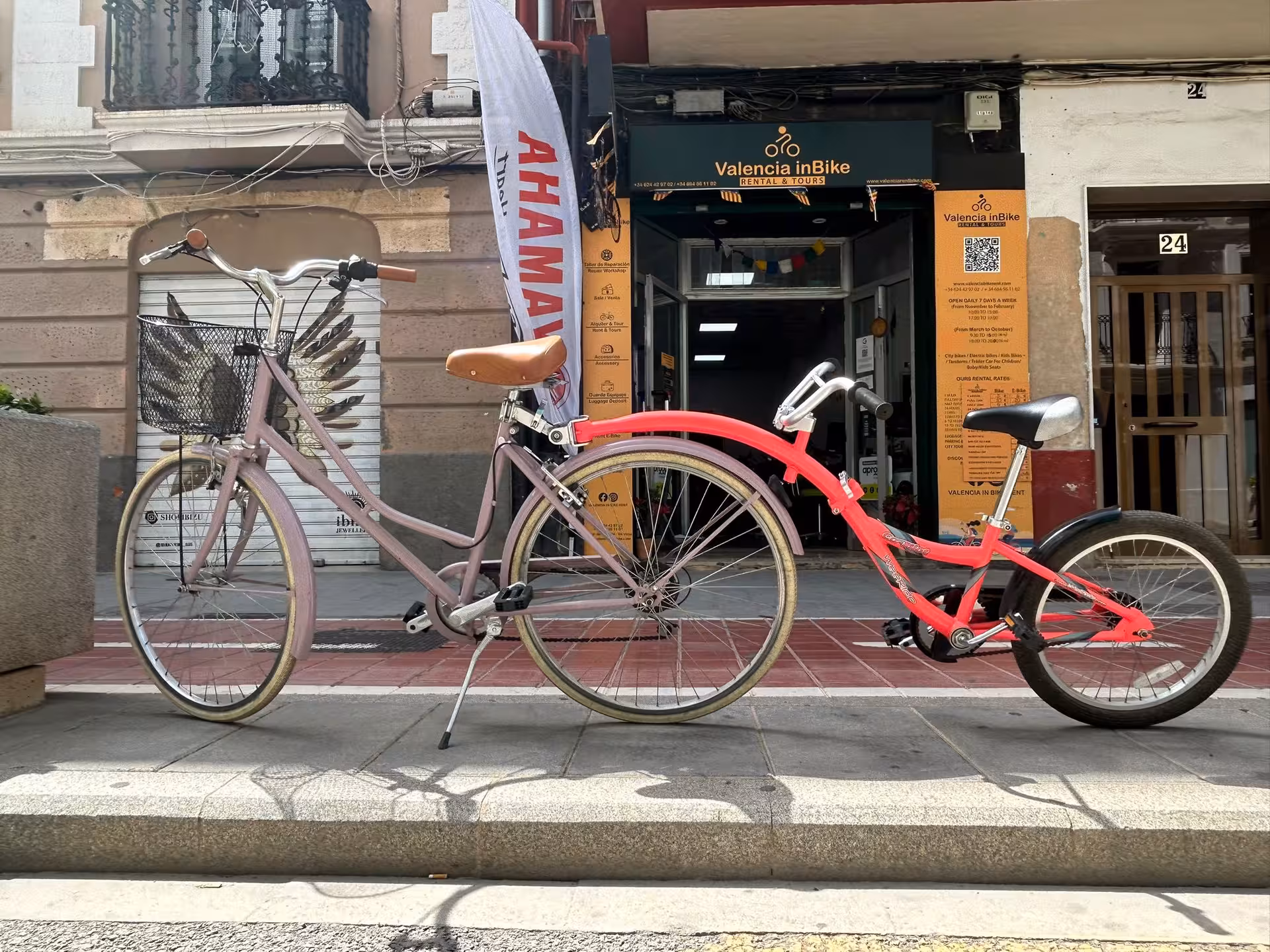 City bike and kids trailer bike parked outside Valencia inBike rental shop for tandem and family cycling tours in Valencia.