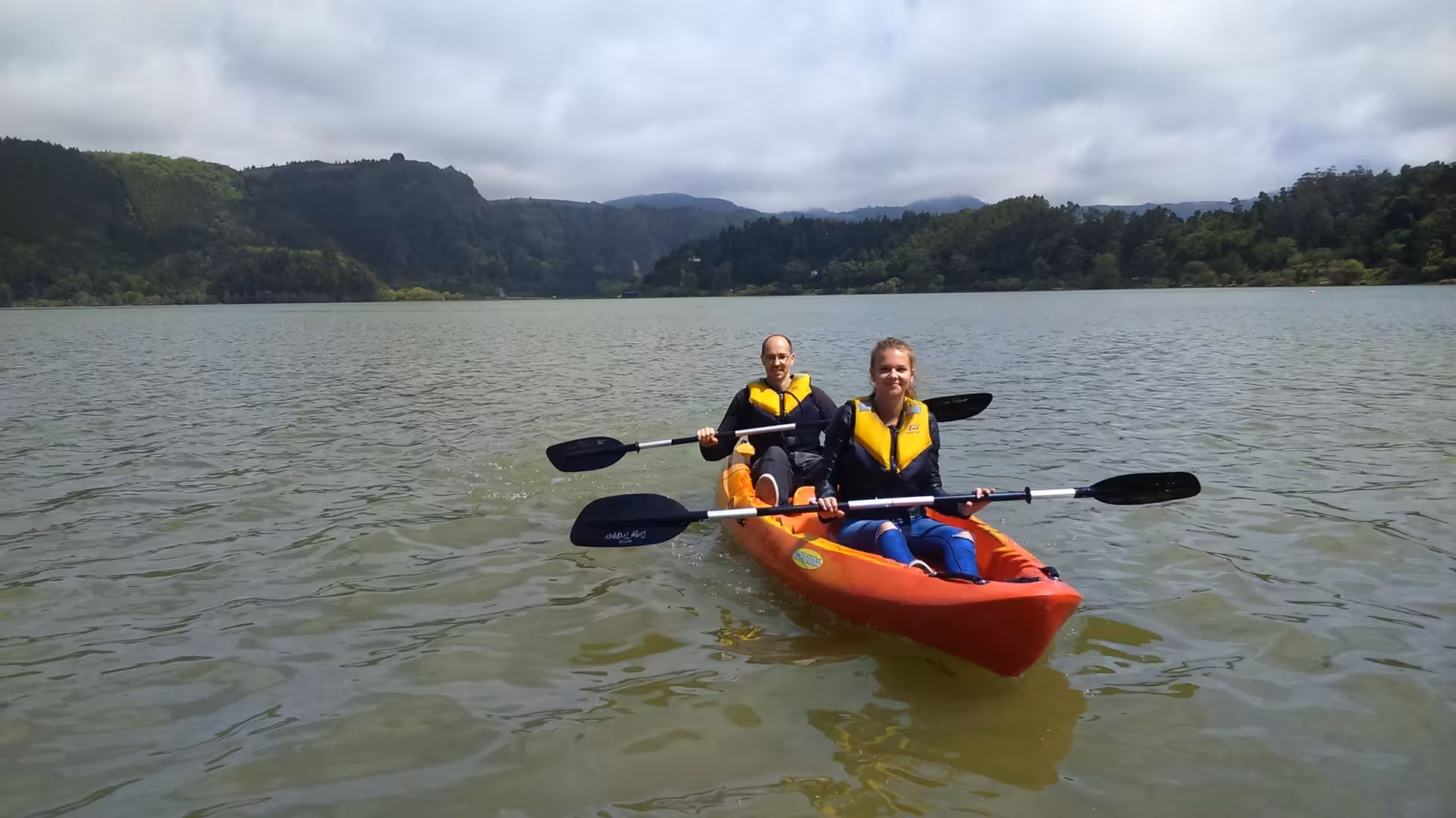 Two paddlers in a tandem kayak on a calm lake, ideal for a half-day canoeing tour without transportation