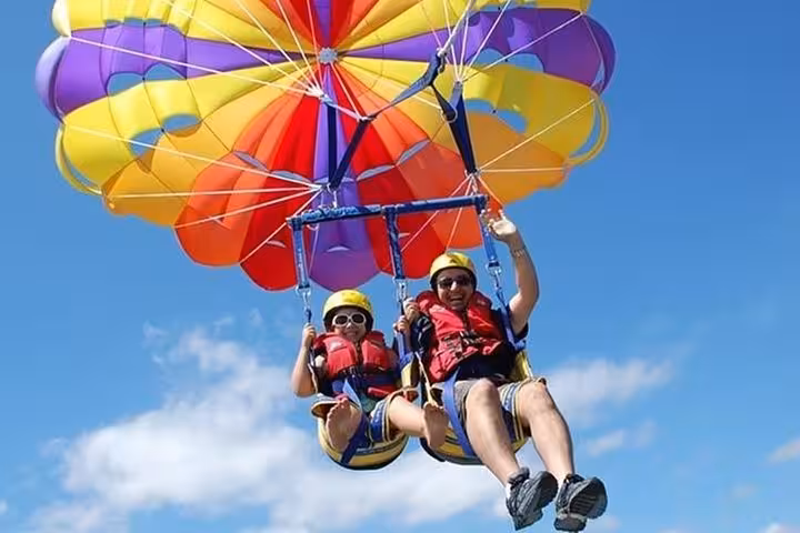 Tandem parasailing over the Red Sea in Hurghada with colorful canopy, Sahl Hasheesh and Makadi Bay views