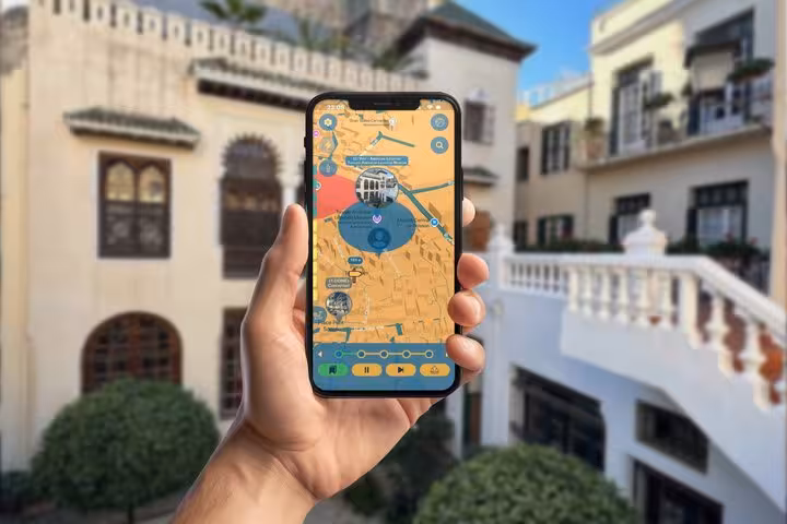 Hand holding smartphone with GPS walking tour map app in Tangier International Zone
