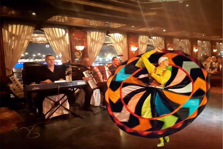 Tanoura dancer spins in colorful skirt with live band on Nile River night dinner cruise in Cairo at evening
