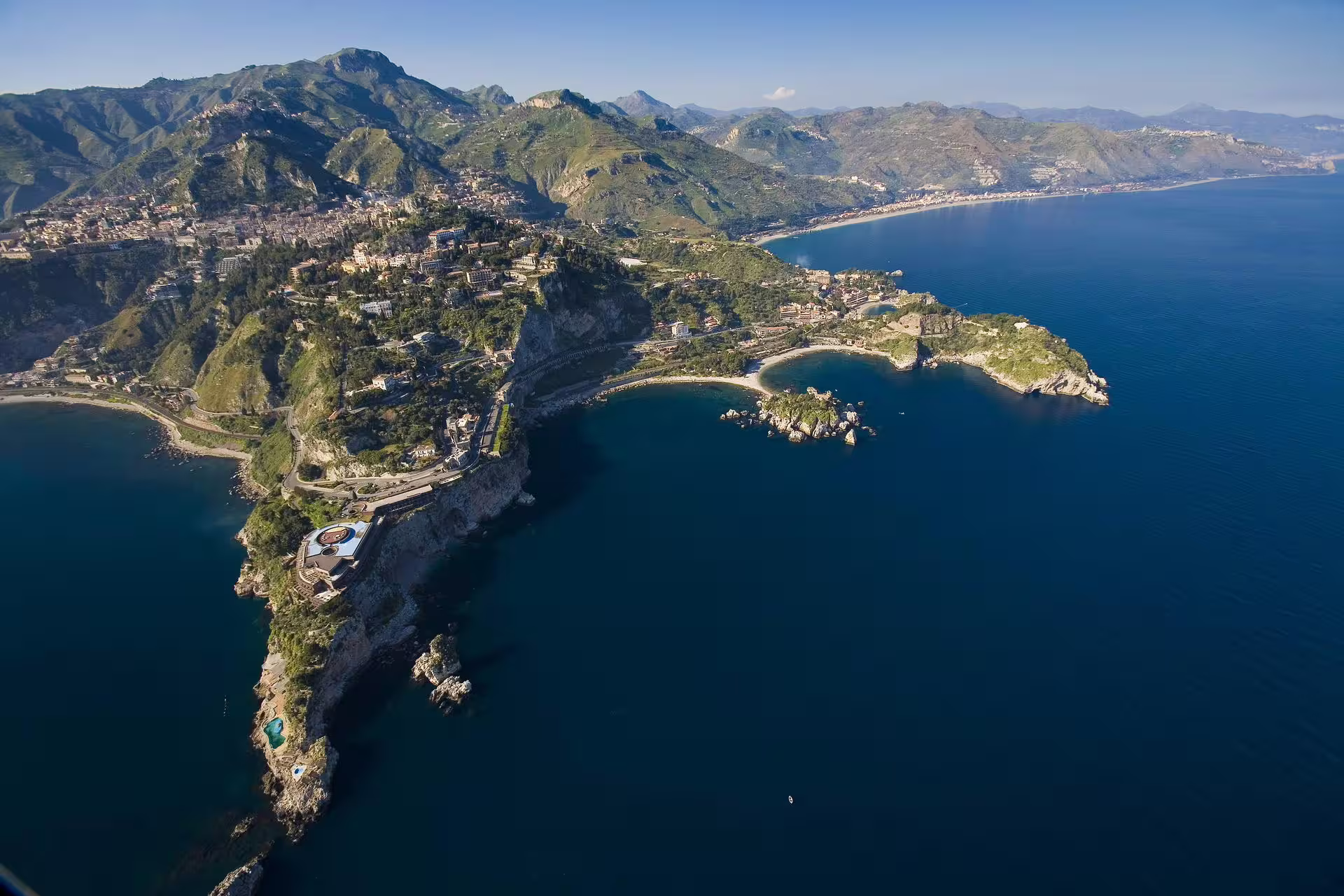 Aerial view of Taormina coastline and bays on a private boat tour, crystal-clear Ionian Sea, Sicily