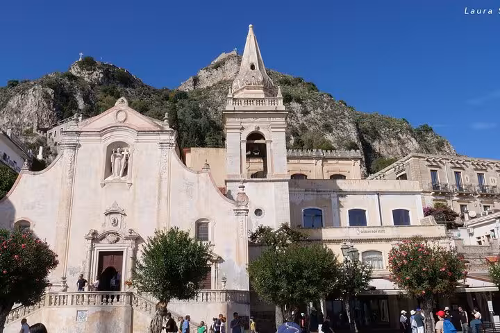 Explore historic architecture and scenic views in Taormina's charming town square, ideal for cultural tours.
