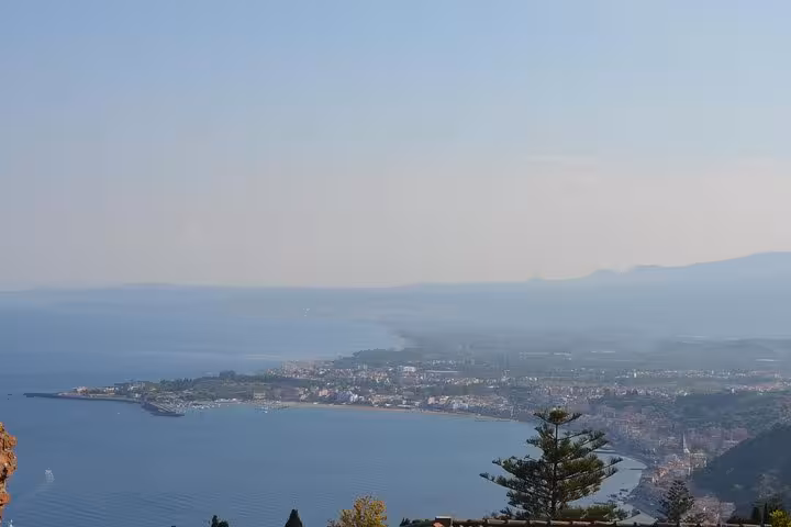 Scenic view of Taormina coastline with azure waters and lush greenery, perfect for a relaxing Sicilian getaway.