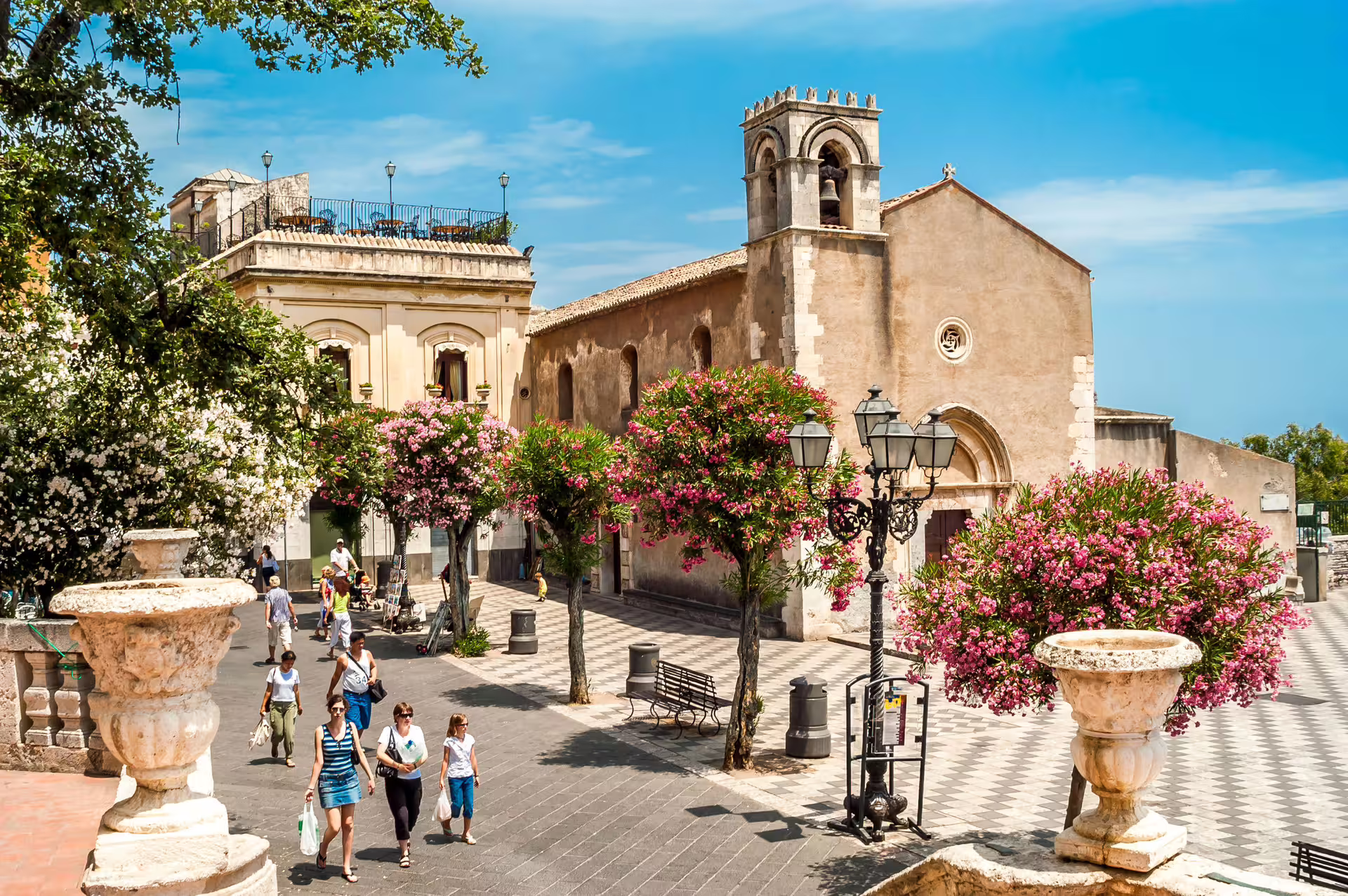 Taormina piazza with flowering trees and historic church, scenic stop on Catania Port shore tour