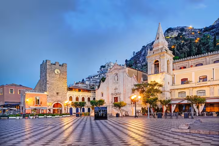 Piazza IX Aprile in Taormina at dusk with church and clock tower, highlight of Etna winery tour from Messina port